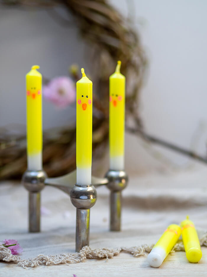 Diese einfache Deko-Idee für DIY Küken Kerzen zu Ostern ist ganz leicht nachzumachen. Tauche weiße Kerzen in gelbe Farbe und male ein Gesicht auf – fertig ist das Küken! Anleitung auf johannarundel.de.